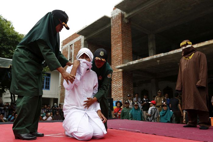 В Индонезии девушку публично наказали за секс вне брака (4 фото)