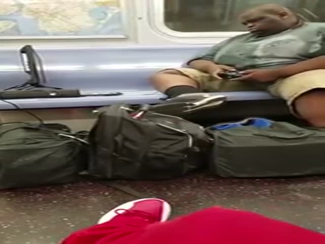 Пассажир нью-йоркского метро играет в приставку