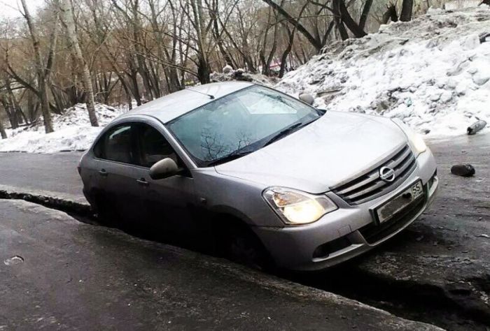 В Омске машины проваливаются в ледяные трещины на дорогах (3 фото)
